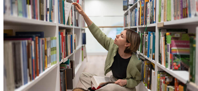 Thoughtful-Woman-Browsing-Library-collection