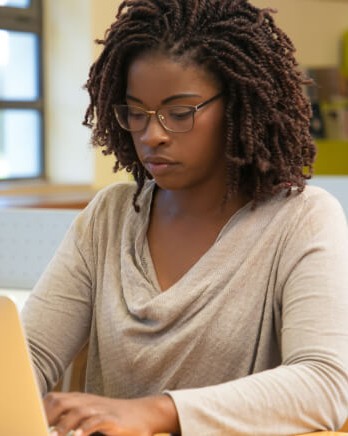 Two-people-working-on-laptops-in-library
