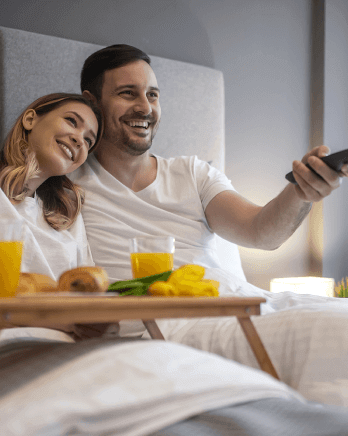 happy-couple-watching-tv-in-hotel-1